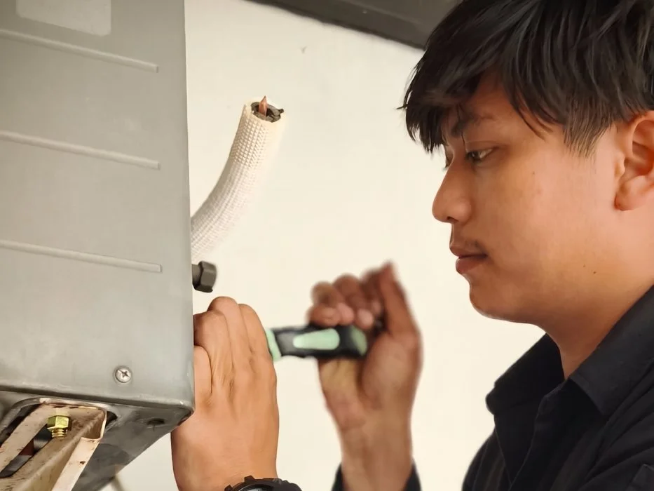Teknisi sedang memeriksa unit HVAC
